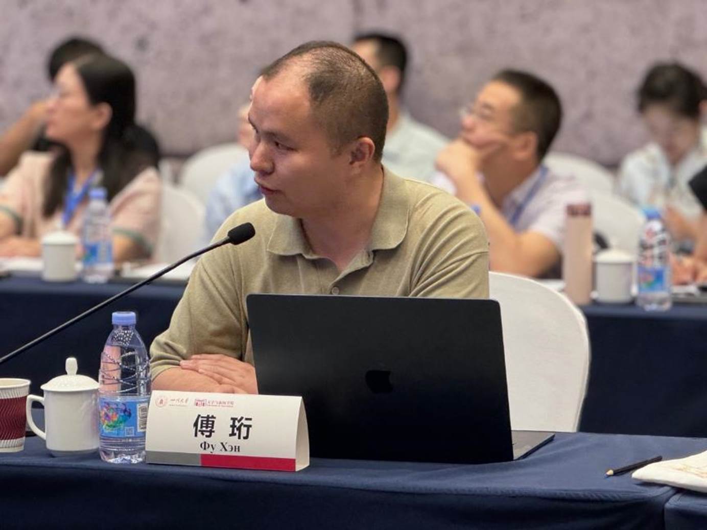 桌子上放着笔记本电脑前的人群AI 生成的内容可能不正确。